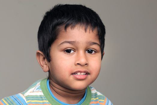 An handsome Indian kid smiling in front of the camera
