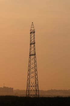An telecommunication tower during the early morning mist and light