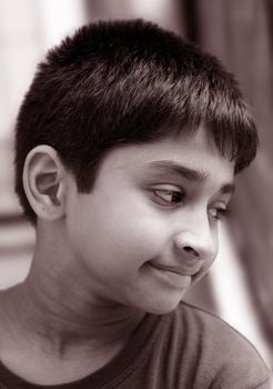 Handsome Indian kid looking pensive through a window