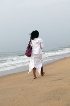 An young woman strolling down the beach