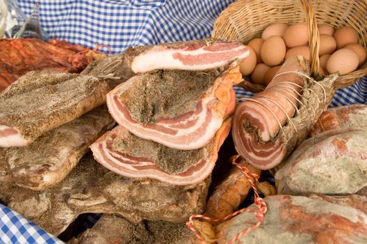 Cold meat and eggs on a market stall.