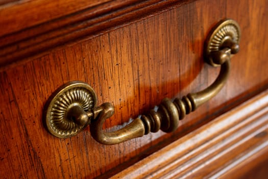 The ancient handle on a case door, as an element of design of an interior of apartment.