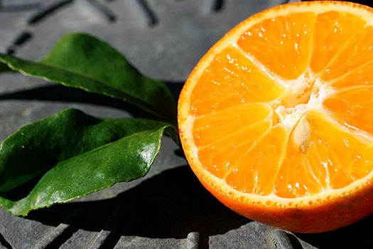 Half of a tangerine with leaves on a sundial.