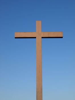 A wooden Christian cross over a blue sky