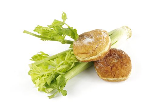 Contradiction between healthy food and junk food using celery and jam doughnut on a reflective white background 