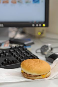 Office business lunch food cheese hamburger, desktop and financial newspaper on office desk 