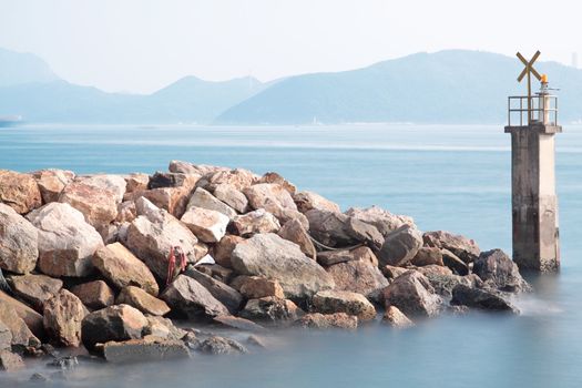 Lighthouse on a Rocky Breakwall: A small lighthouse warns of a rough shoreline. 