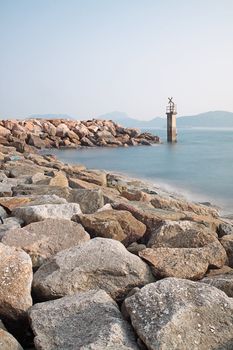 Lighthouse on a Rocky Breakwall: A small lighthouse warns of a rough shoreline. 