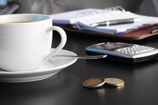 coffee and organizer in a black table showing break or breakfast in office