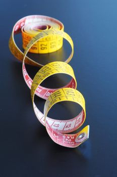 measuring tape on blue or black background showing tailor concept