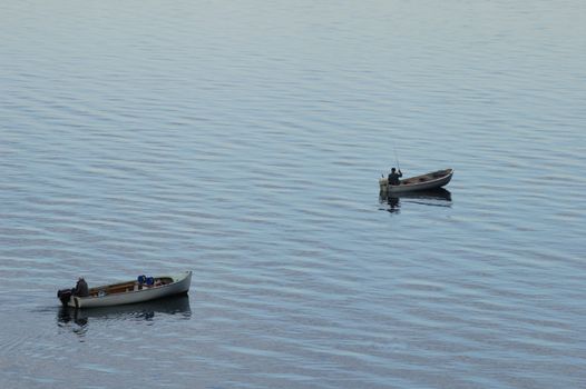 One fisherman slowly sneaks up on another who is casting his line. Is this a good spot for fishing?