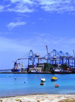 Detail of crane over stacked containers in freighting port in the Med