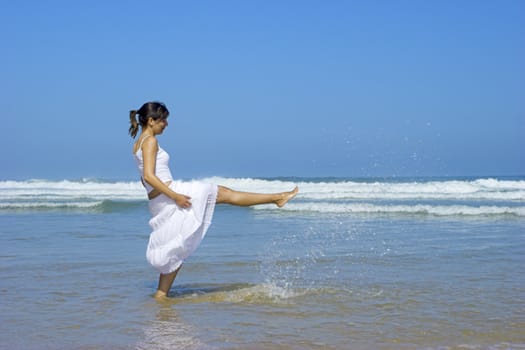 Beautiful woman spreading water on the beach