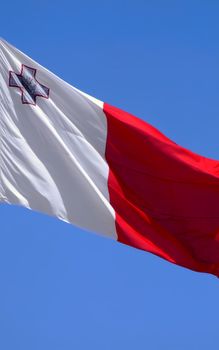 The national flag of the island Republic of Malta - proudly displaying the George Cross awarded to Malta in 1942 for Gallantry shown in WWII