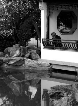 Lonely woman in an authentic Asian garden      