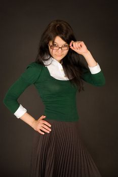 Serious looking girl in glasses isolated on black