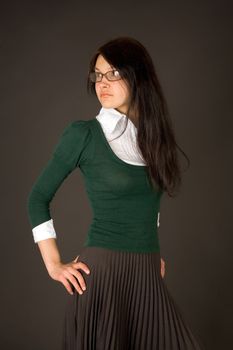 Serious looking girl as teacher or businesswoman isolated on black
