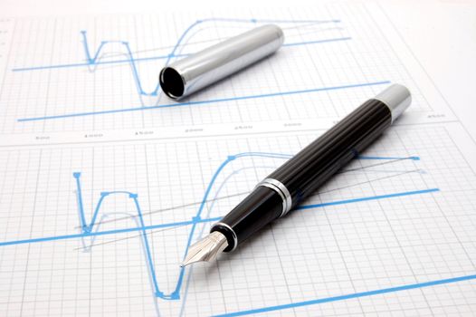 black fountain pen on business stock chart