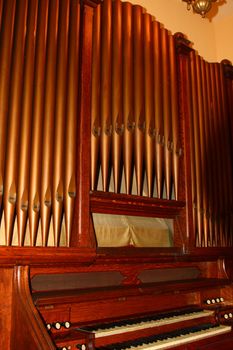 antique pipe organ showing brass copper pipes