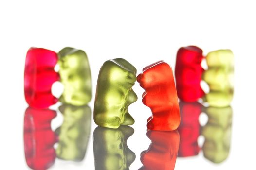 sweet gummy bears dancing on a party on white background