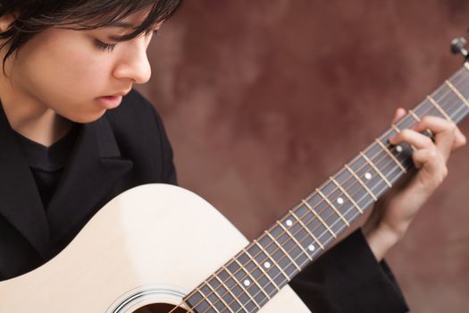 Attractive Ethnic Girl Enjoys Playing Her Guitar.