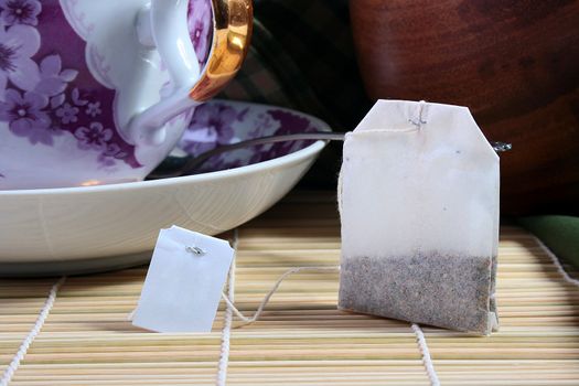 Paper bag with tea and the big cup for tea on a background.