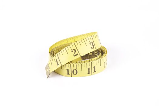 Yellow curled tape measure with a reflective white background
