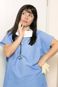 Nurse standing with hand on hip and thinking or making an assumption

