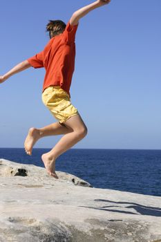 Boy leaps into the air with outstretched arms
