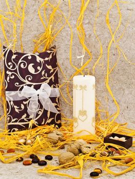 holiday decoration with gift box, candles and nuts against beige background