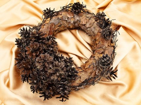 Christmas handmade garland with natural decorations over golden textile background  
