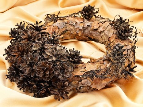 Handmade garland with natural decorations over golden textile background  