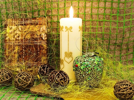New Year composition with gift, candle and toys against abstract background 