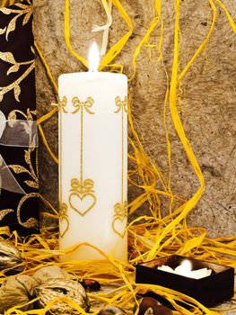 holiday decoration with candles and nuts against beige background  