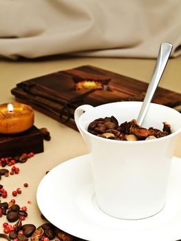 decorated table serving with candle, coffee beans near cup at beige 