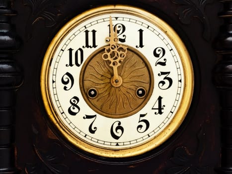 old wooden clock with  golden hands show twelve  