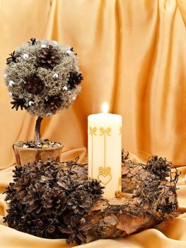 handmade garland, decorative little tree with candle against golden textile background