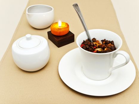 decorated table serving with candle, coffee beans in cup at beige 