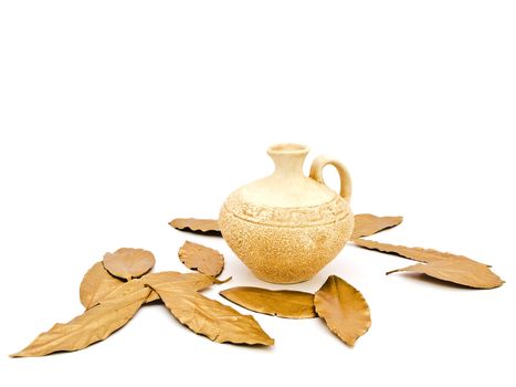 Photo of ancient beige vase and golden bay leaves against white background 
