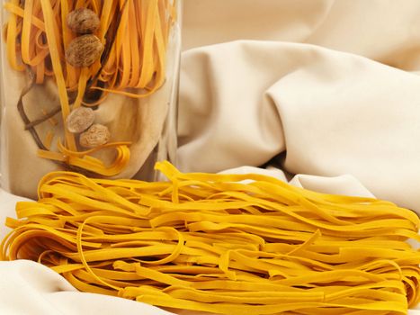 chili pasta at beige textile and decorated in vase with nutmegs 