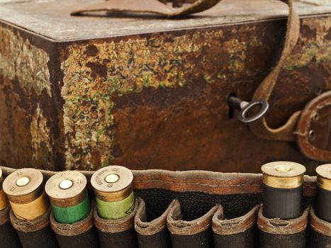 Some old cartridge for hunting rifle against vintage rusty chest
