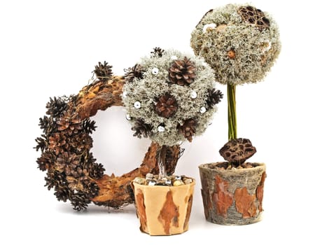 Handmade decorative trees from pine tree and cones with wreath against the white background 