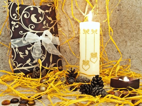 festive composition with gift, candle and cones against abstract background