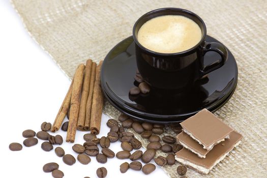 cup of italian espresso with cinnamon, coffee beans and chocolate