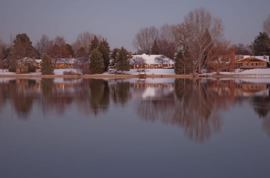 luxury houses with mature trees on a lake shore at dusk in winter scenery, Fort Collins, Colorado