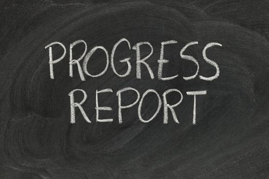 progress report headline handwritten with white chalk on blackboard with eraser smudges