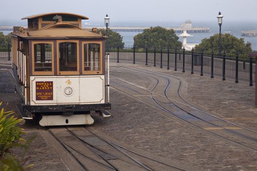 San Francisco cable car at Hyde Street turntable (Fisherman's Wharf) with foggy Aquatic Park in background