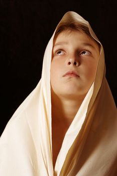 Humble child in simple cloth lifting up his eyes to heaven