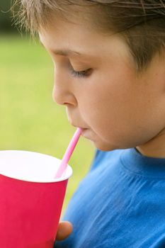 Child drinks a milkshake from a disposable cup