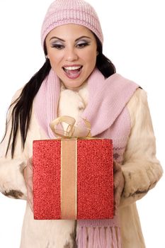 Beautiful brunette holding a large red box tied with gold gauze ribbon with a gleeful,  surprised expression.